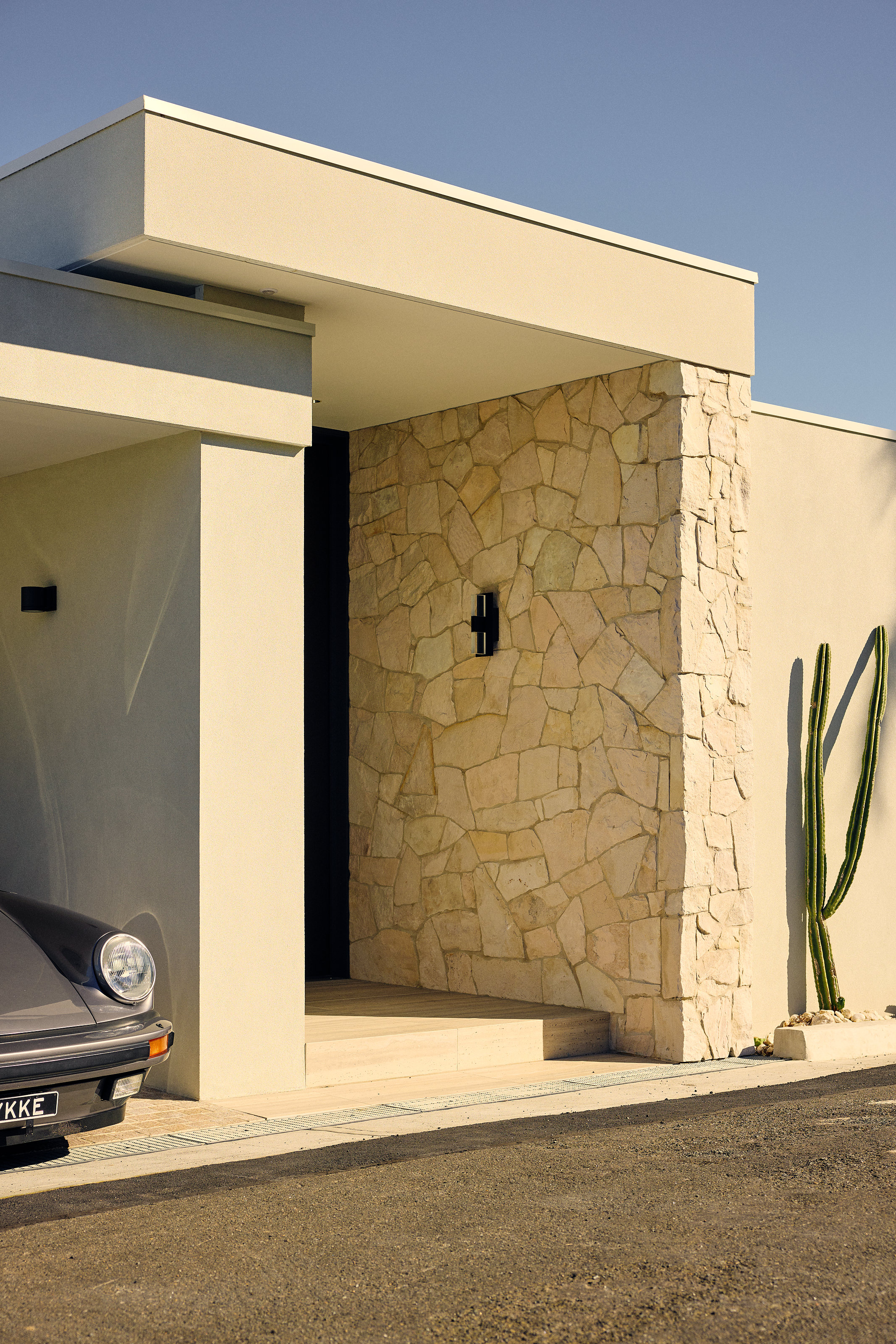 Palme Hus, entry portico, stone pier and cactus, car in the garage beyond