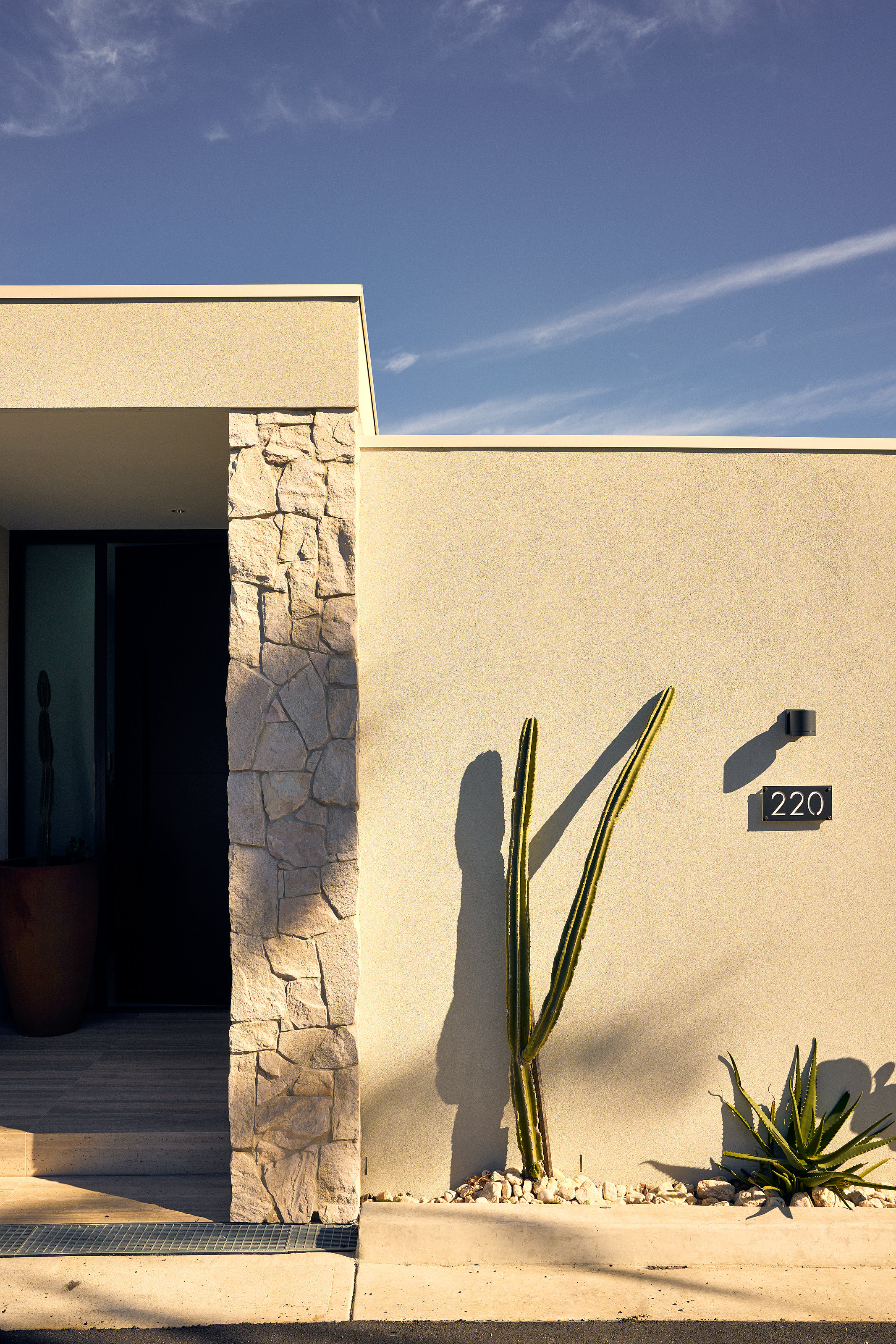 Palme Hus, front door open past the stone pier, cactus and gravel garden