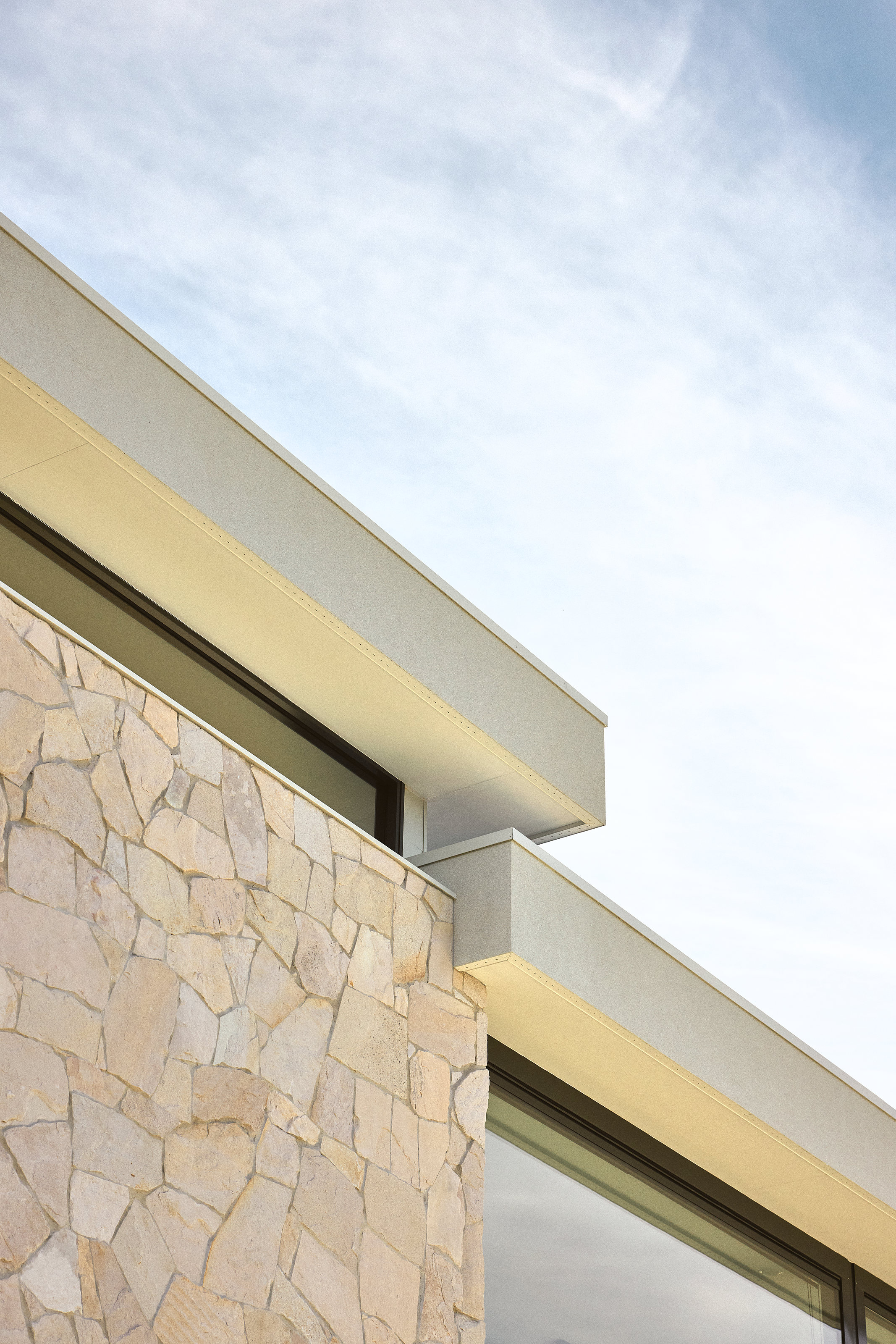 Palme Hus, eaves line and stone wall against the sky