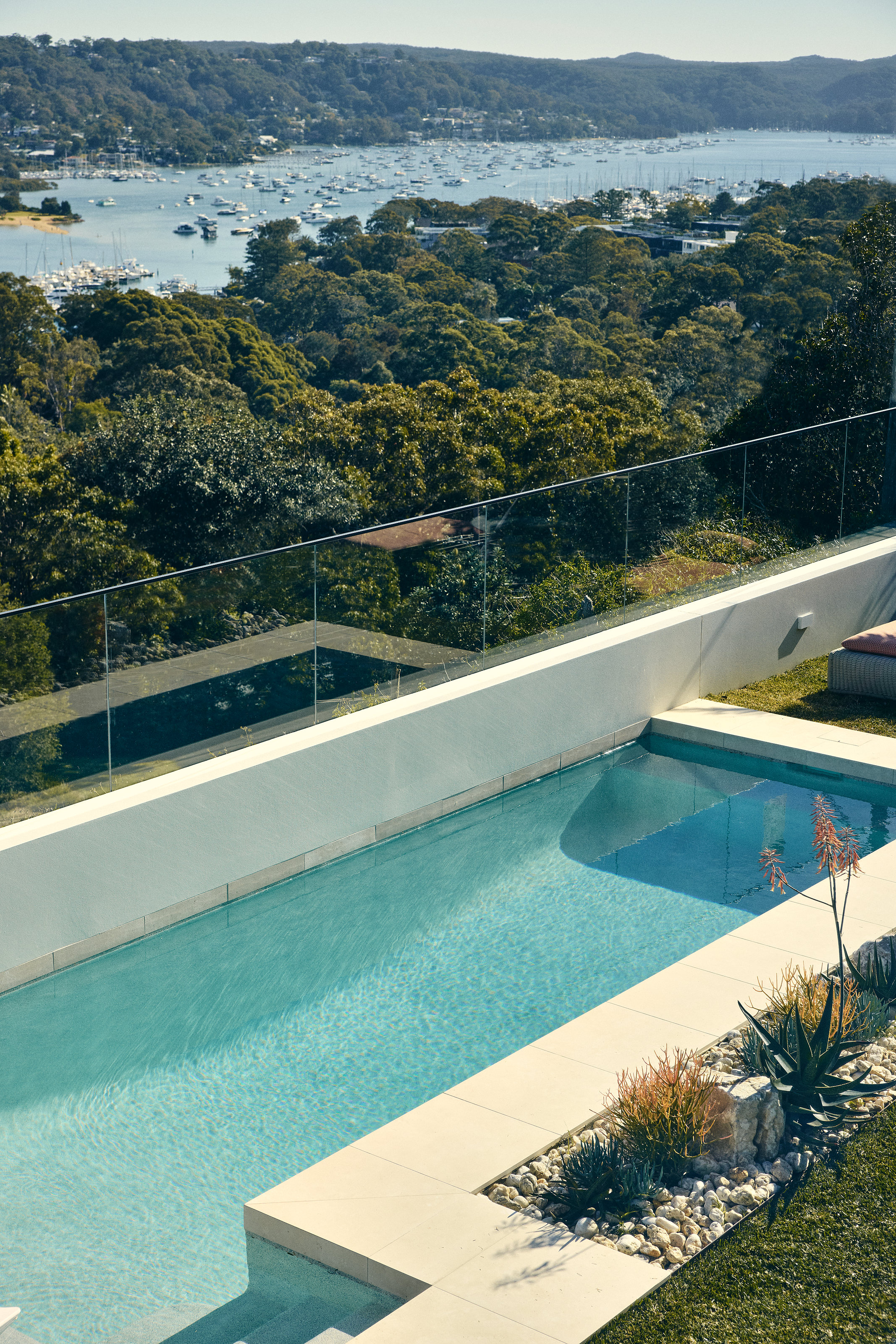 Palme Hus, lap pool and glass balustrade, Pittwater and moored boats beyond