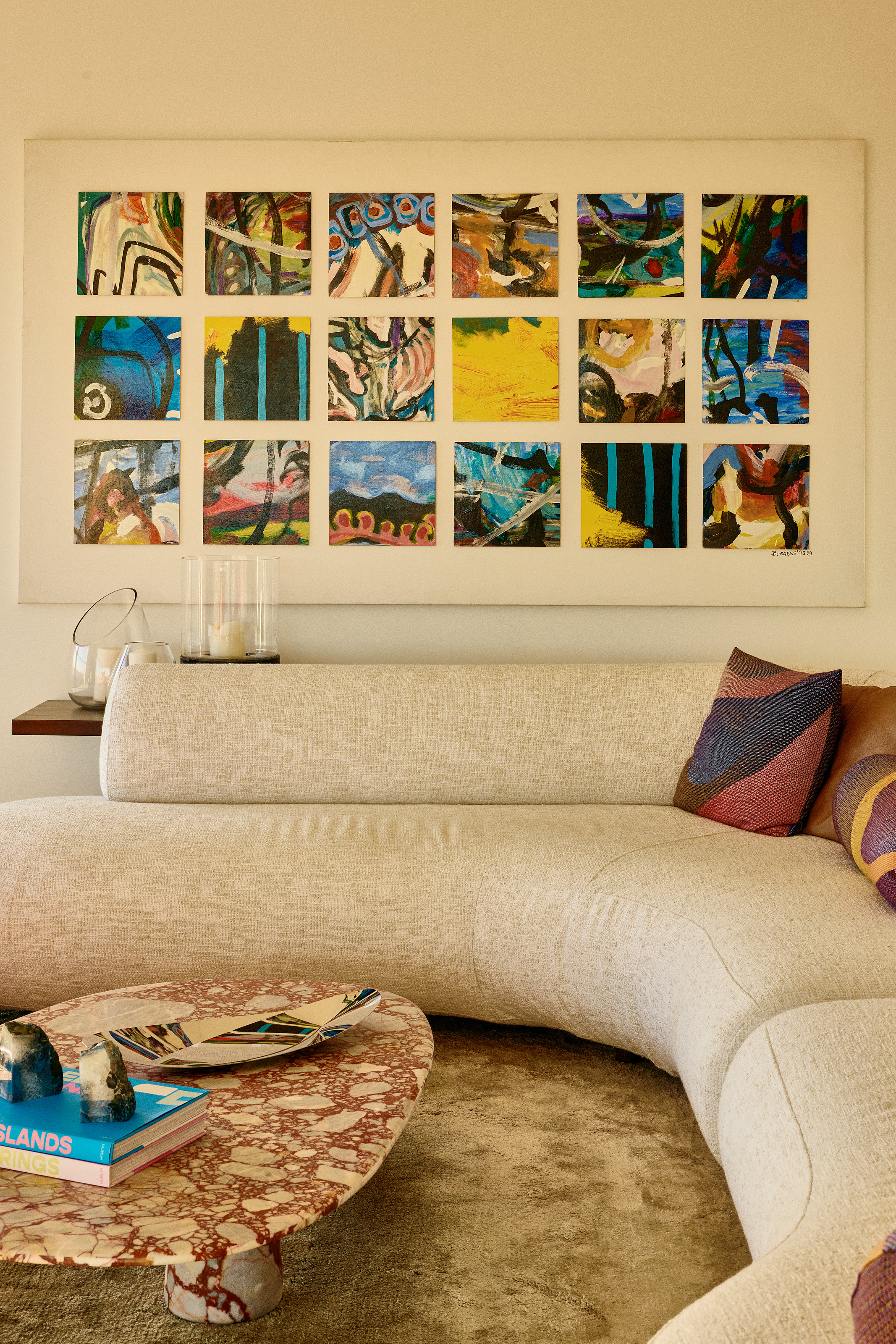 Palme Hus, curved sofa and stone table under a framed artwork